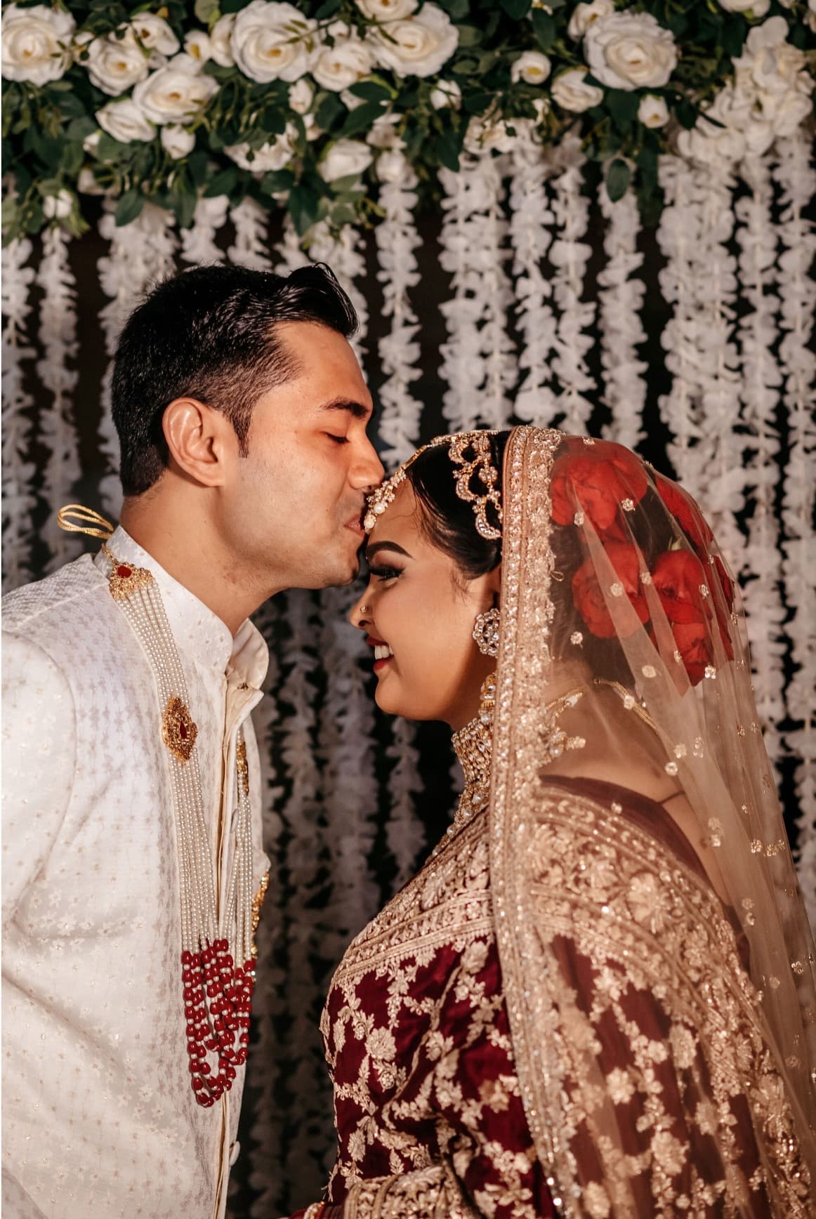 Groom kissing his bride's forehead at an Upstate New York wedding