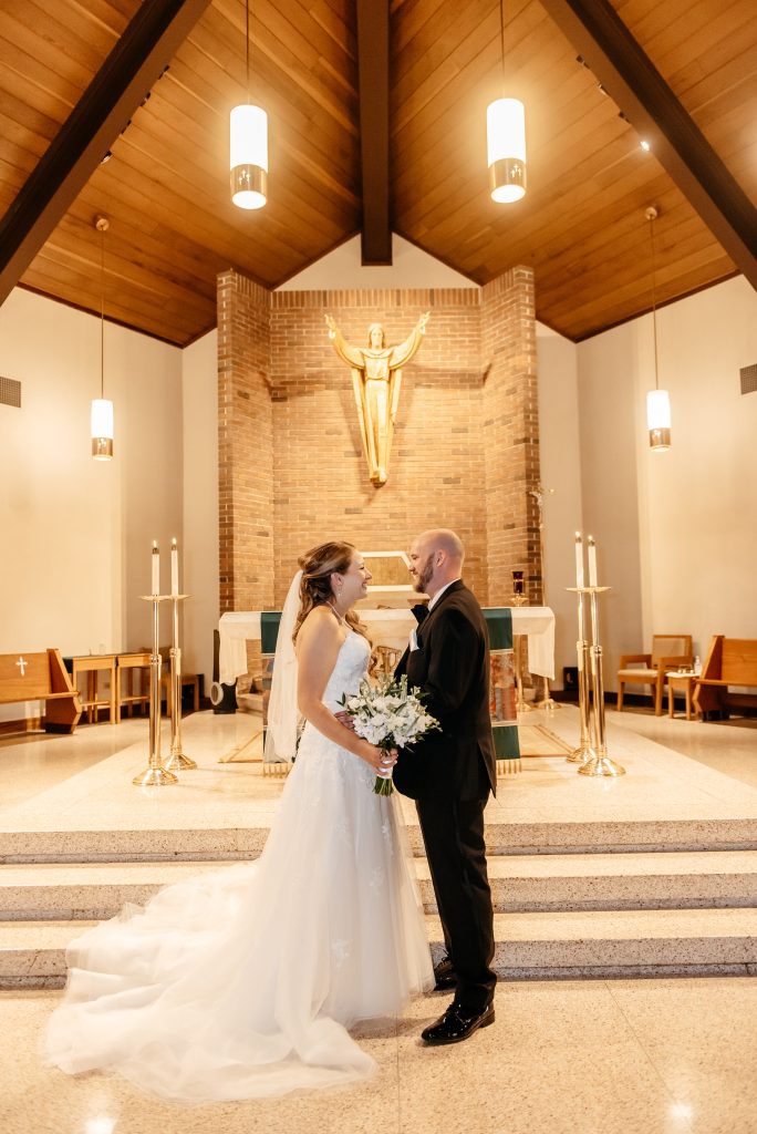 A bride and groom are getting married in new york at a church with wooden ceilings and marble floors