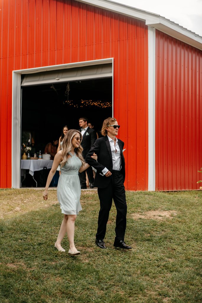 A bridesmaid and a groomsman walk to the reception area where their friends are getting married in new york