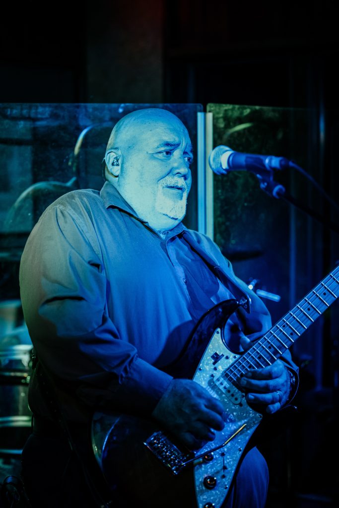 A man plays the electric guitar at a reception knowing the average cost of a weddingin upstate ny