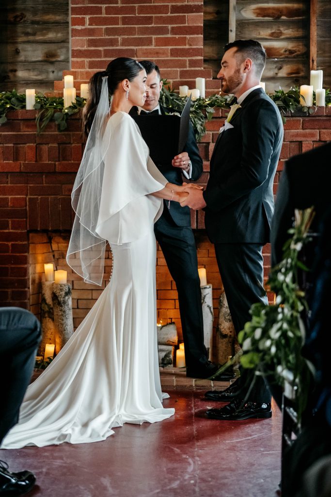 A bride and groom hold hands at the alter of their Upstate New York wedding venue