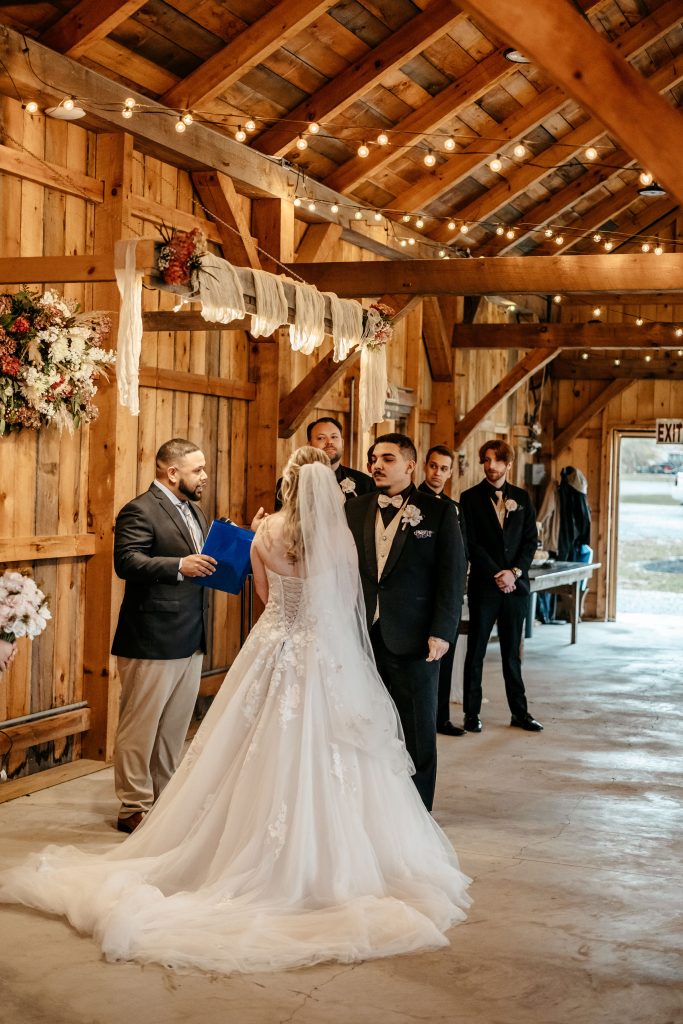 A bride and groom stand at the alter in front of their guests at Gables and Gardens wedding venue