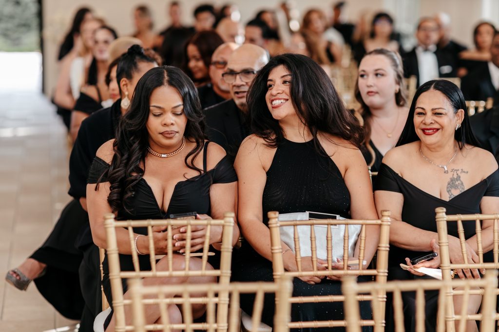 Bridesmaids wearing black dresses smile for natural wedding photos