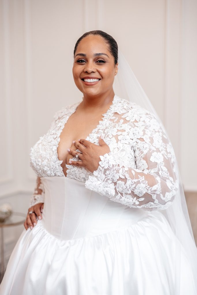 A bride in a lace wedding gown poses for her new york wedding photos